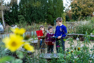 School children in the rain garden with clipboards