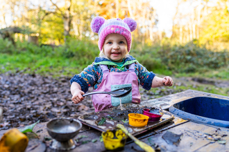 Young child at mud kitchen by Adrian Clarke