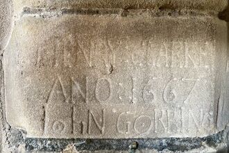 Picture of a stone with wording carved on it from a church tower