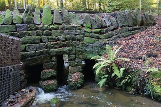 A drystone bridge over a stream in a woodland