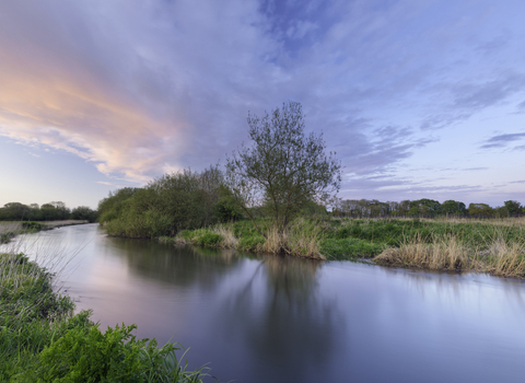 A scenic view of a river at dusk.