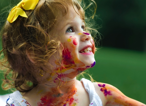 Girl covered in paint playing outside