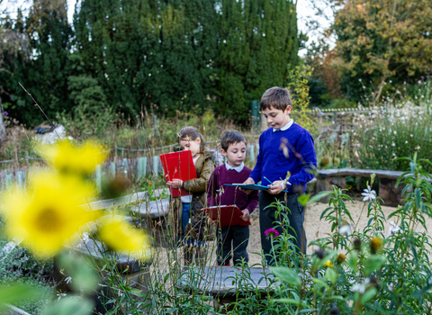 School children in the rain garden with clipboards