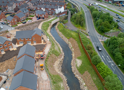 An aerial image of a new river channel by houses